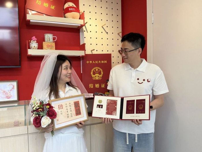 5月20日，“花漾生活・爱在闵行”集体婚礼在闵行文化公园举行，新人们获赠专属婚书。 闵行区供图