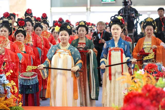 5月20日，山东青岛崂山区，集体婚礼现场，执礼喜娘分别手持如意、博山炉、鸳鸯、五福葫芦等道具。张进刚/摄