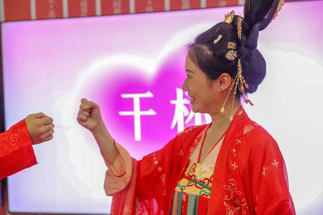 5月20日，山东青岛崂山区，集体婚礼现场，一对新人在做猜拳游戏。张进刚/摄