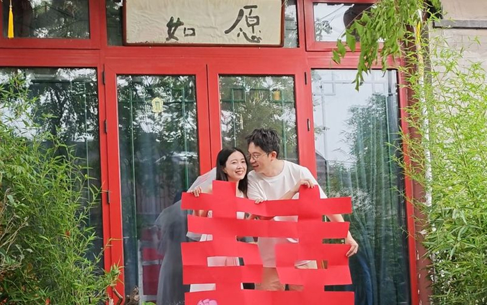 5月20日，西城区大栅栏街道樱桃斜街，一对新人在“如愿”小店门前合影。新京报记者 王巍 摄