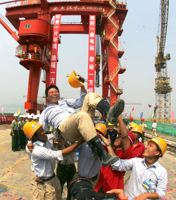 2006年5月20日，三峡大坝最后一仓混凝土浇筑完毕后，工友们把完成最后浇筑的工人抛向空中。