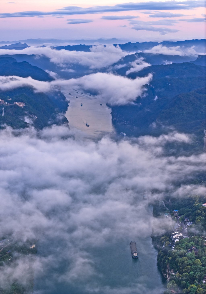 2025年9月，长江西陵峡雨后云雾缭绕，满载货物的船队沿航道穿行。