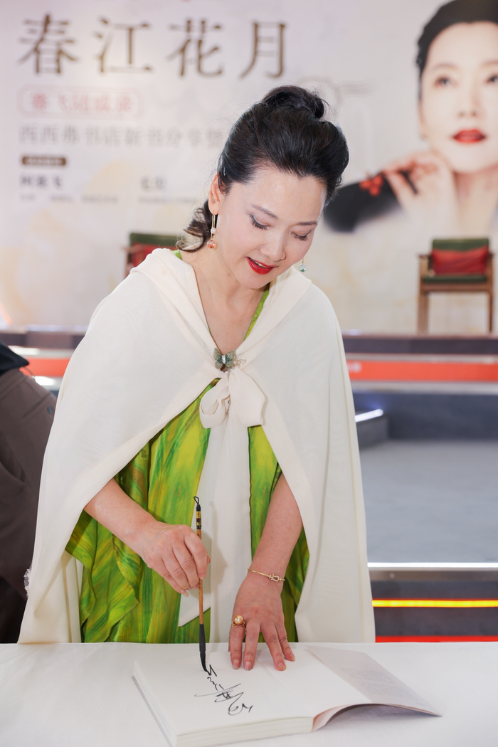 何赛飞为新书签毛笔字  供图：花城出版社
