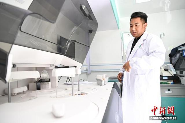 图为波密县人民医院检验科的医生益西旺久在流动体检车内检验血清。中新社记者 贡嘎来松 摄 