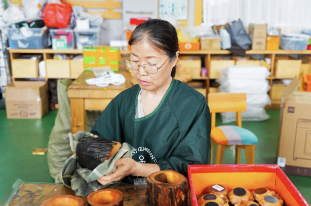 2026年5月12日，伊春永达工艺品有限公司员工正在擦拭制作好的松木工艺品。新华社记者 王祚 摄