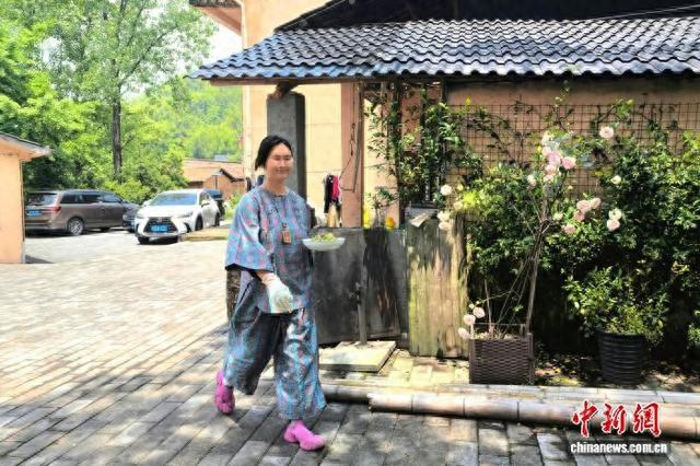 5月10日，江西省宜春市明月山温汤镇水口村的“乐呵呵”农家乐，杨佳蓉端着热气腾腾的农家菜，穿梭在餐桌之间。记者 吴鹏泉 摄