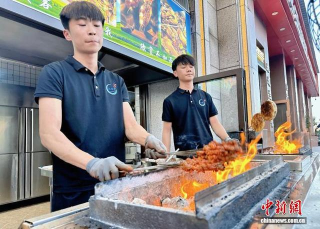 图为5月23日，康乐师傅烤制肉串。高文 摄