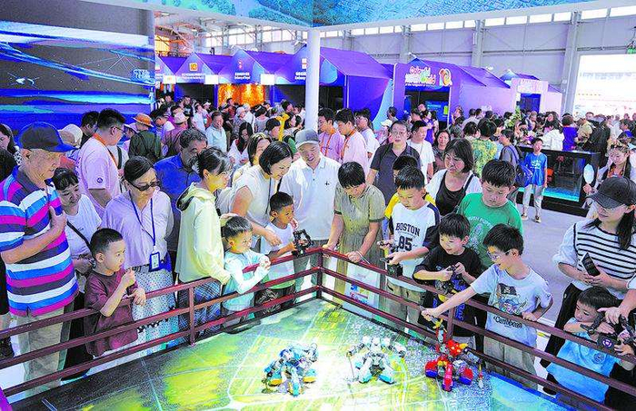 2025年9月14日，首钢园，服贸会文旅服务专题展，观众们围观格斗机器人。　　资料图片/新京报记者　薛珺　摄