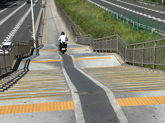 5月13日下午，“卷尺哥”骑车从龙岗区的天桥上经过，这是他很熟悉的一条送货路。新京报记者 胡倩 摄