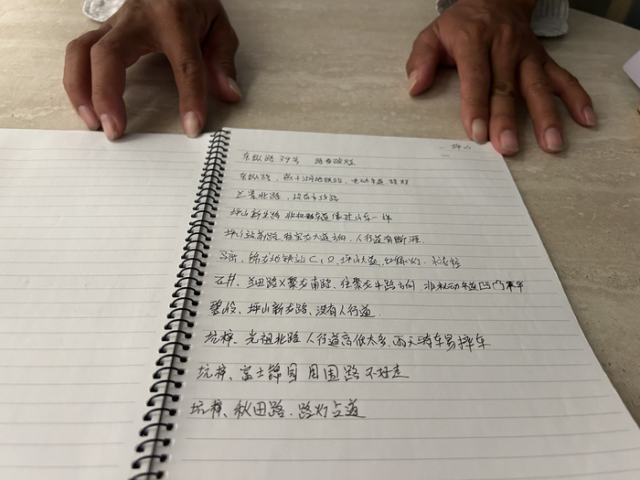 “卷尺哥”的笔记本里记录了网友反馈的道路问题线索。每解决一个，他就在后面打一个“√”。新京报记者 胡倩 摄