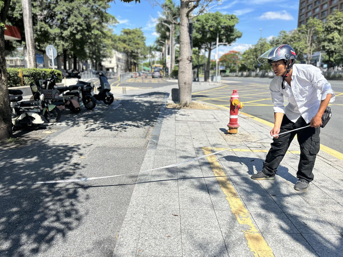 回访之前反映过问题的路段，“卷尺哥”习惯用卷尺测量整改后的宽度、距离。新京报记者 胡倩 摄