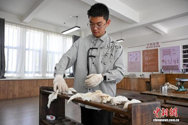 图为6月3日，工作人员将“压制”好的沱茶放入茶架定型。中新社记者 李嘉娴 摄 
