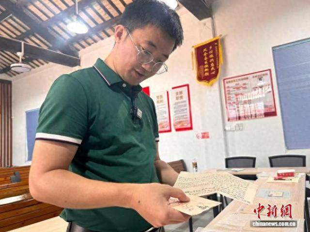 5月25日，海南省文昌市会文镇凤会村党支部书记林健乐向记者介绍村中收藏的侨批。中新社记者 符宇群 摄