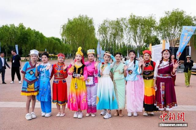 身着民族服饰的大学生与游客互动。 主办方供图