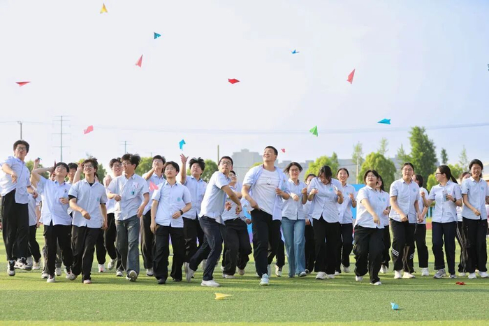 江苏省海安市立发中学高三学生在操场上放飞写有自己心愿的纸飞机。新华社发（顾彬斌摄）