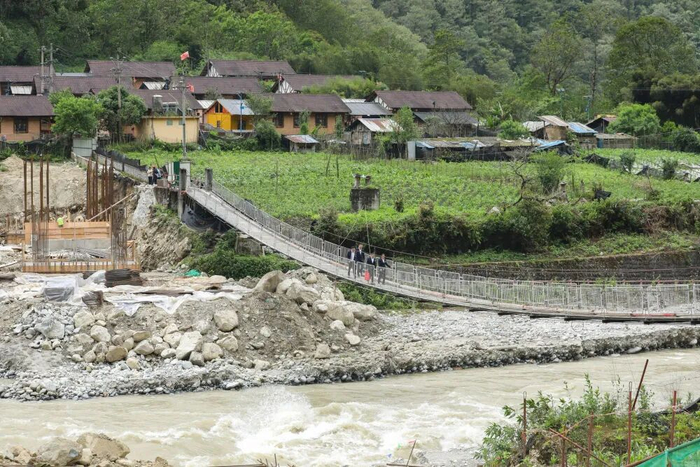 2026年5月28日，贡山县独龙江乡迪政当村，独龙江支行员工在贷款调查路上。郑益 摄