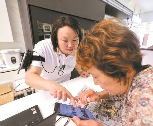             工作人员帮助市民选购心仪的电影票 本报记者  王凯  摄          