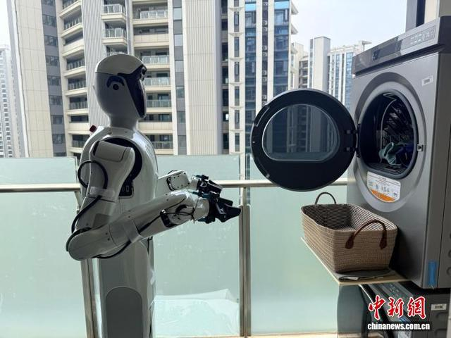 6月5日，一台人形机器人在武汉光谷一间公寓里使用烘干机。武一力 摄