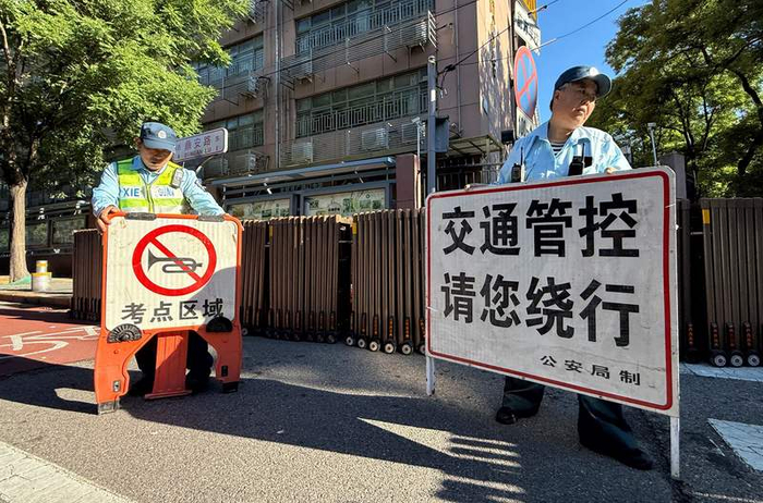 广渠门中学，工作人员摆放交通管控请绕行和禁止鸣笛标识。新京报记者 王贵彬 摄