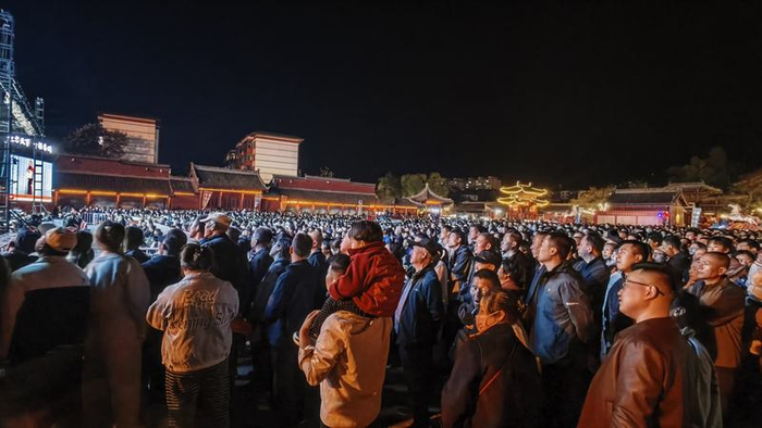 2026年4月，西安演艺集团青年团在甘肃天水伏羲庙表演，一个孩子坐在家长肩膀上观看。图源：西安演艺集团青年团