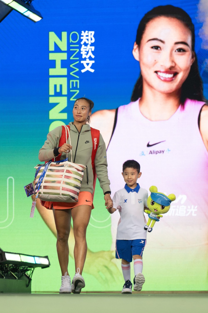 10月9日，郑钦文（左）在比赛前步入赛场。新华社记者 肖艺九 摄
