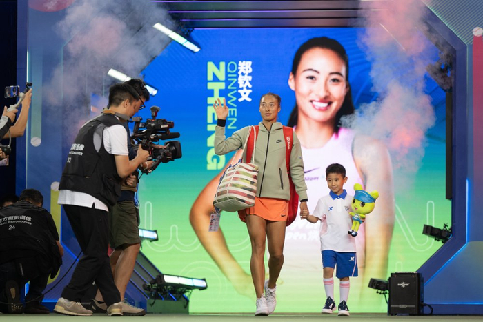 10月9日，郑钦文（右二）在比赛前步入赛场。新华社记者 肖艺九 摄