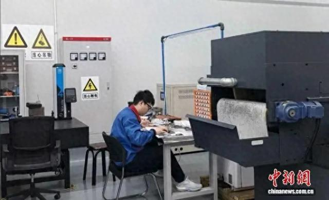工作人员在生产车间测量零部件。李钊 摄