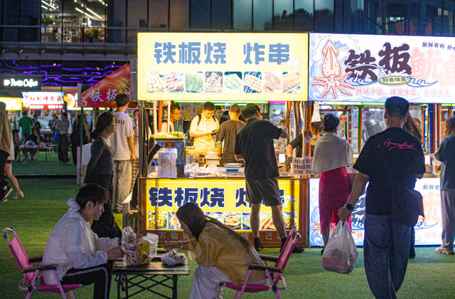 美食摊位前人头攒动。张磊/摄