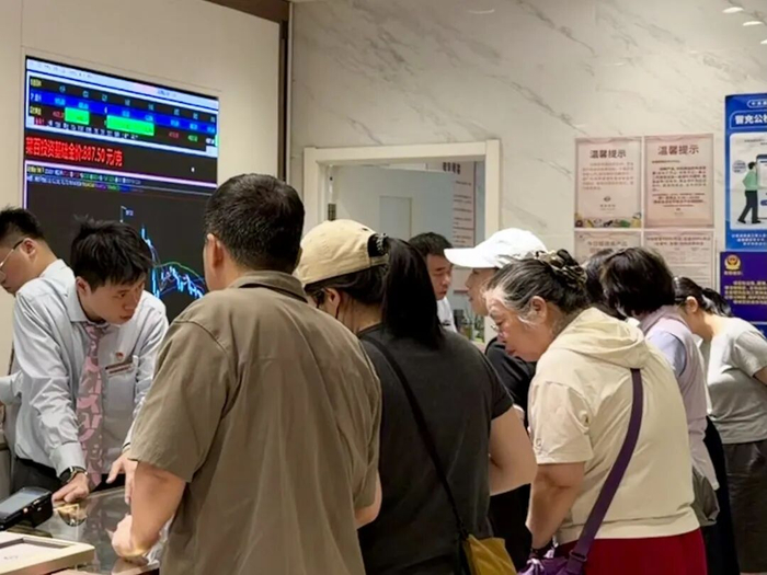 6月11日上午，菜百首饰总店四层投资金条柜台前，消费者围在柜台前咨询、开票。 罗文利/摄
