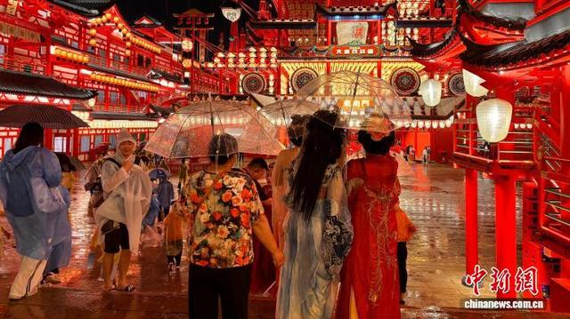 6月13日晚，游客在唐山河头老街景区冒雨游览。 张会杰 摄