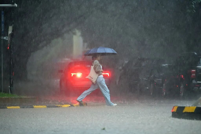 △14日，广州天河区，一位手持雨伞的女子在大暴雨中过马路。