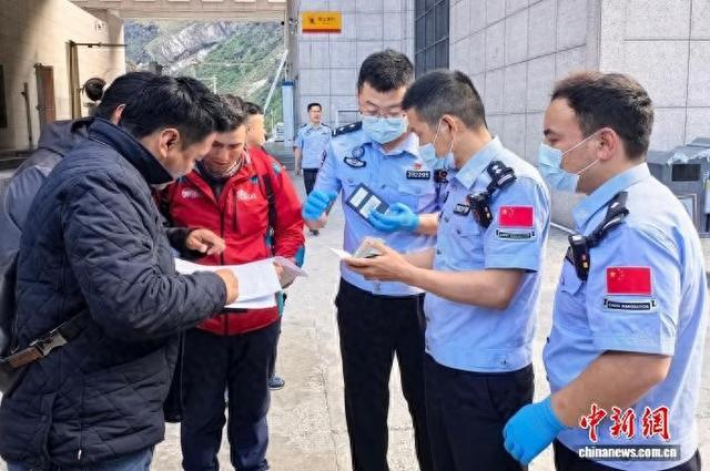 图为吉隆出入境边防检查站执勤二队执勤民警向出境旅客收取护照。肖富贵 摄
