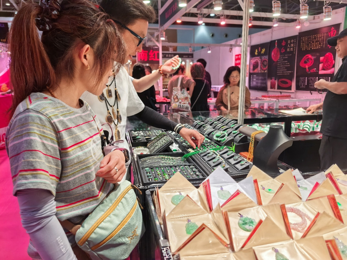 图为观众在挑选轻量款翡翠饰品。