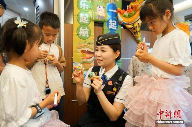 列车车厢被五彩花绳、古风荷包等端午民俗挂件精心点缀。孙浩 摄