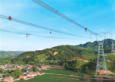 图为6月17日，在大同—怀来—天津南1000千伏特高压输电线路工程河北省承德段，电力工人进行高空作业。