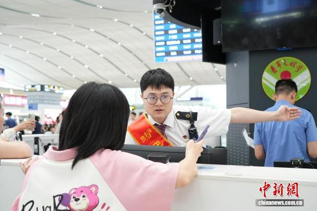“迎春花”服务队为旅客提供指引。田恬 摄