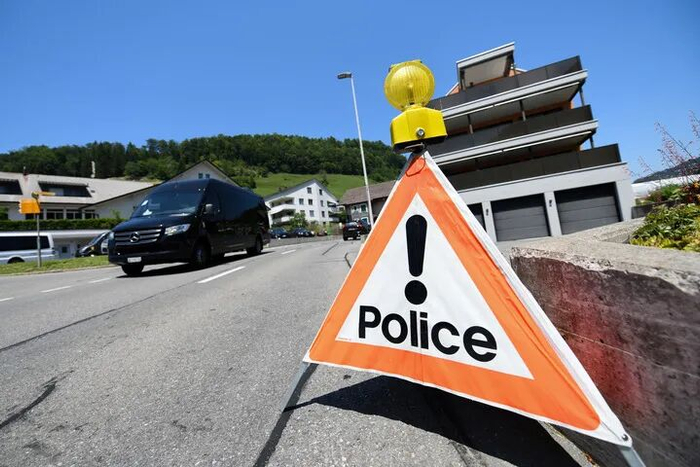 6月19日，在瑞士卢塞恩附近的比尔根山，一辆汽车在通往酒店建筑群的道路入口附近路过一个警示牌。新华社记者 连漪 摄
