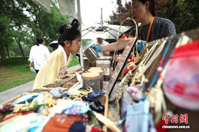 6月19日，北京丰台，2026年“花开丰台”端午游园会在南苑森林湿地公园启幕。图为小朋友体验香囊制作。 中新社记者 富田 摄