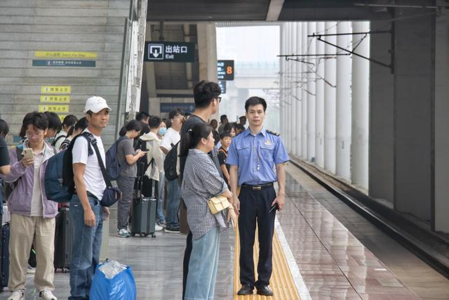 阜阳西站工作人员组织旅客有序检票进站。 谷晨 摄