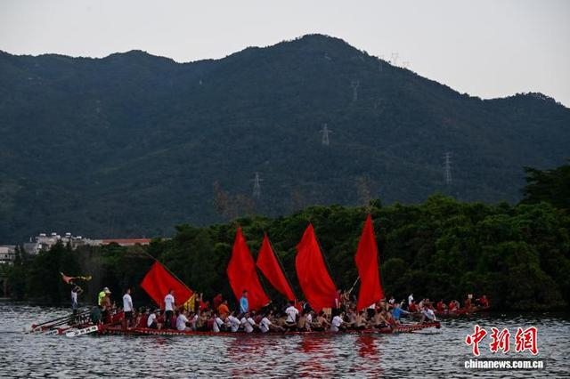 图为龙舟活动结束，参加龙舟赛的兄弟村展示主办村赠送的标旗。中新社记者 陈楚红 摄