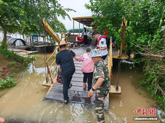 6月22日，广西来宾市象州县运江古镇58人被洪水围困。图为海事执法人员协助转移被困民众。唐晶 摄