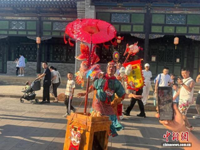 端午假期，杨翔在太原古县城表演，吸引游客围观。 中新网记者 杨静 摄