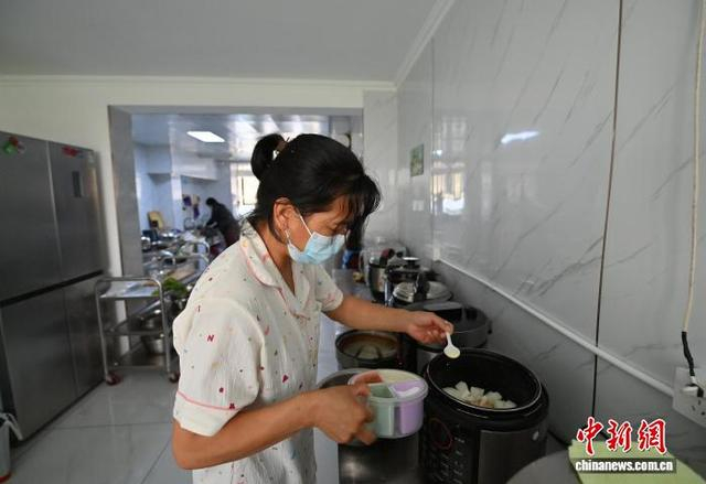 6月23日，在吉林长春的一间“爱心厨房”里，患者家属正忙着为住院治疗的亲人做饭。中新社记者 张瑶 摄