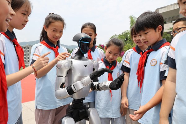 　　2026年6月3日，位于重庆市沙坪坝区的重庆商务职业学院人工智能学院，小学生们与机器人互动。 IC photo
