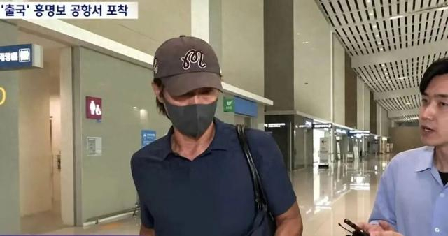 在仁川国际机场，洪明甫受到韩媒记者追问。韩国图自韩媒