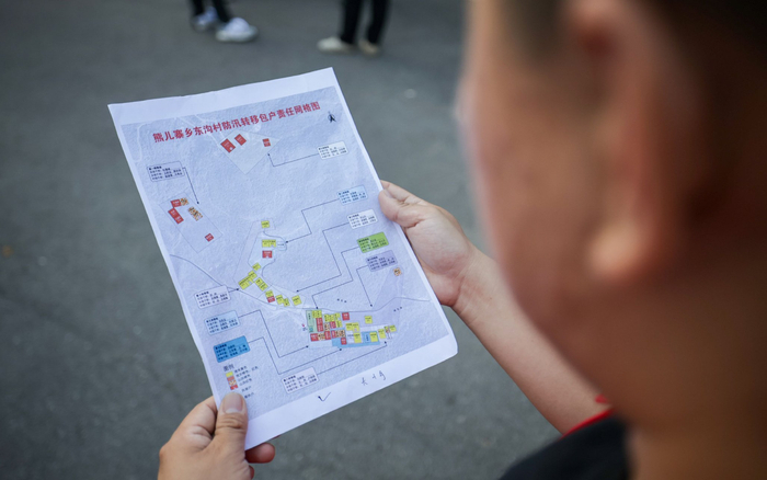 南岔村，工作人员根据防汛转移包护责任网络图挨家挨户通知。新京报记者 王子诚 摄