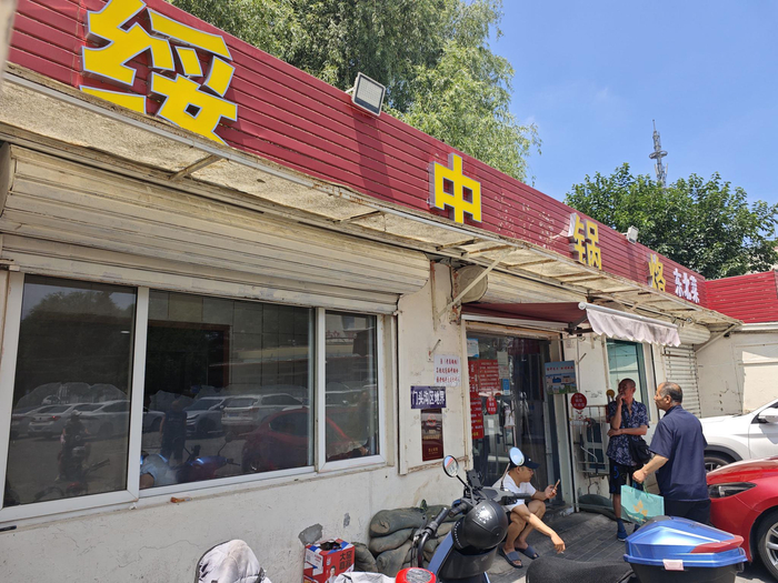 顾客在老娄家的饭馆门外抽烟。新京报记者 郭懿萌 摄