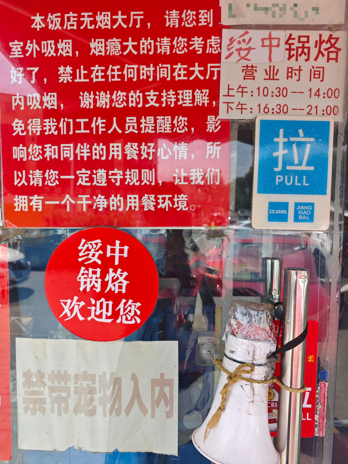 饭馆门上贴着禁烟标语，喇叭里播放着老娄录的禁烟音频。新京报记者 郭懿萌 摄