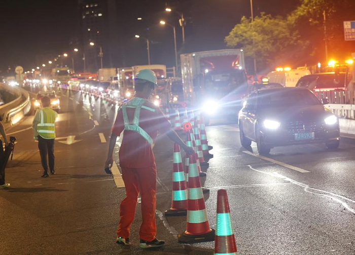 月坛南桥，养护人员对道路进行导行。新京报记者 王贵彬 摄