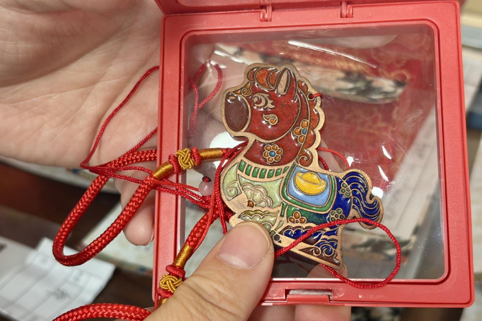 图为游客展示的景泰蓝手工制作成品。